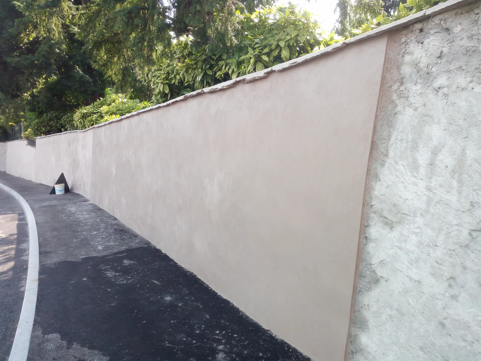 Muro di cinta intonacato lungo la strada dopo la ristrutturazione