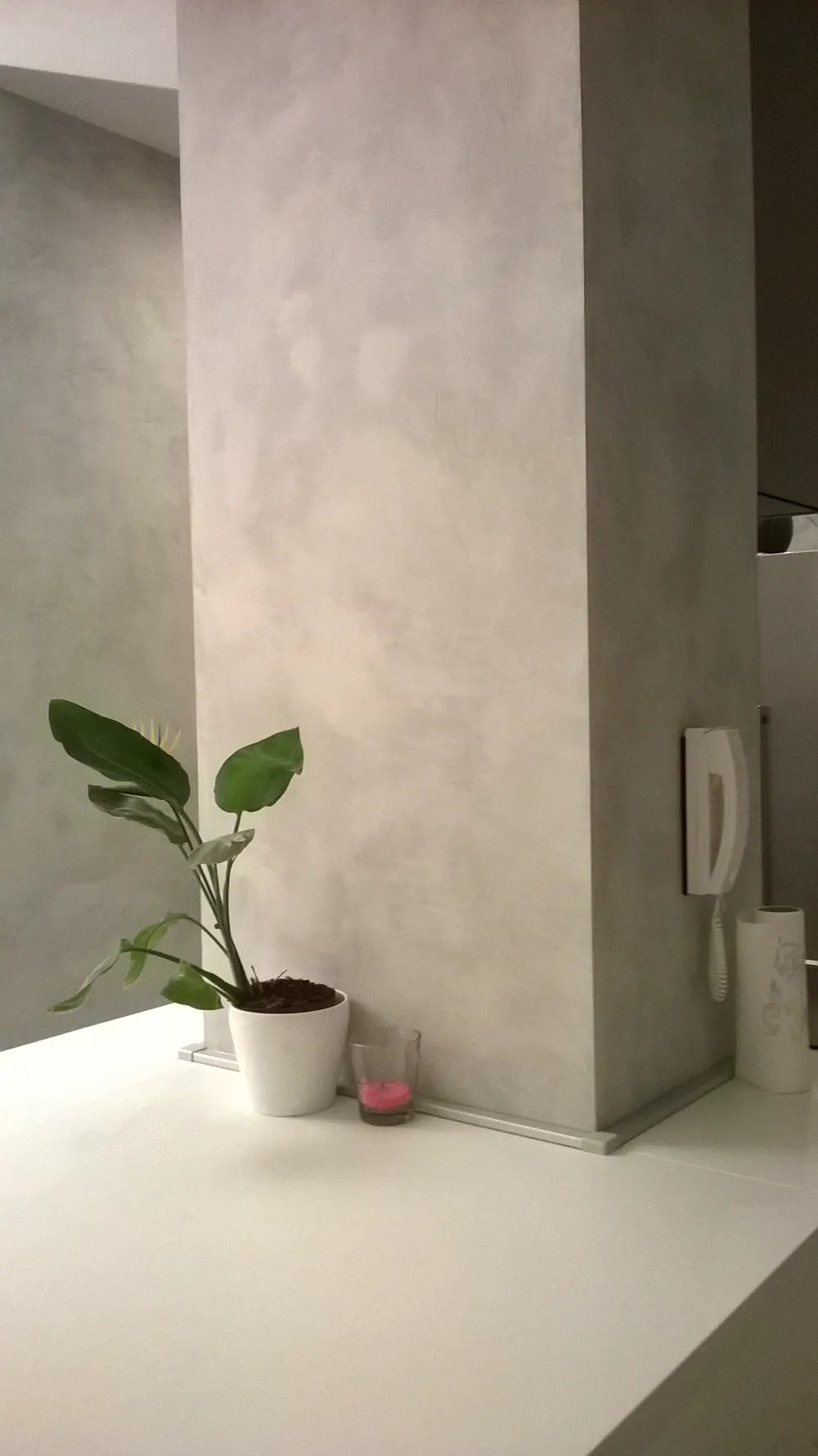 Colonna e parete rifinite in microcemento grigio